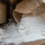 Rozsypana mąka na półce sklejona w grudki cienką pajęczynką